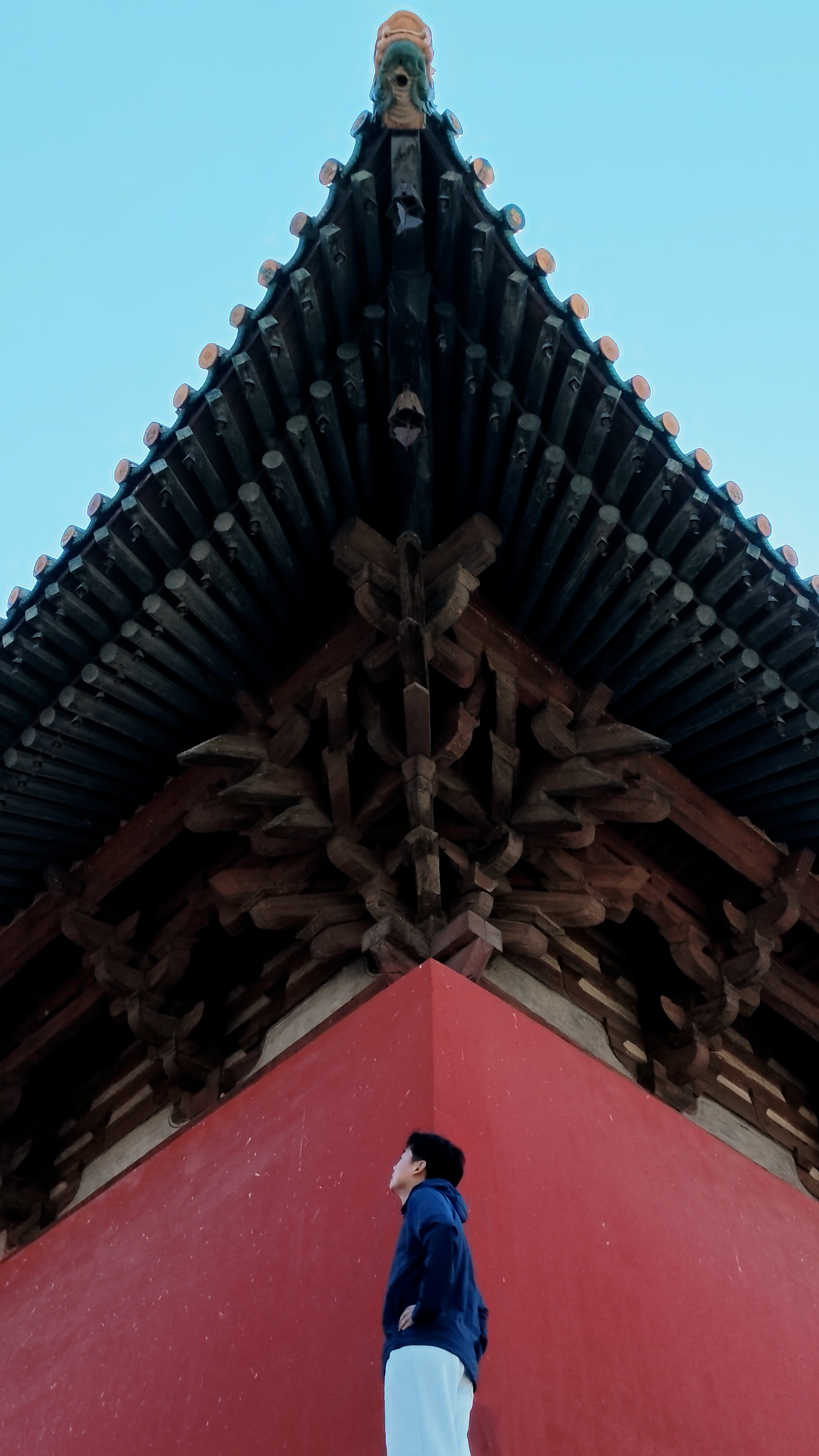 Eric looking up at timber brackets at Chongfu Temple in Shuozhou, Shanxi
